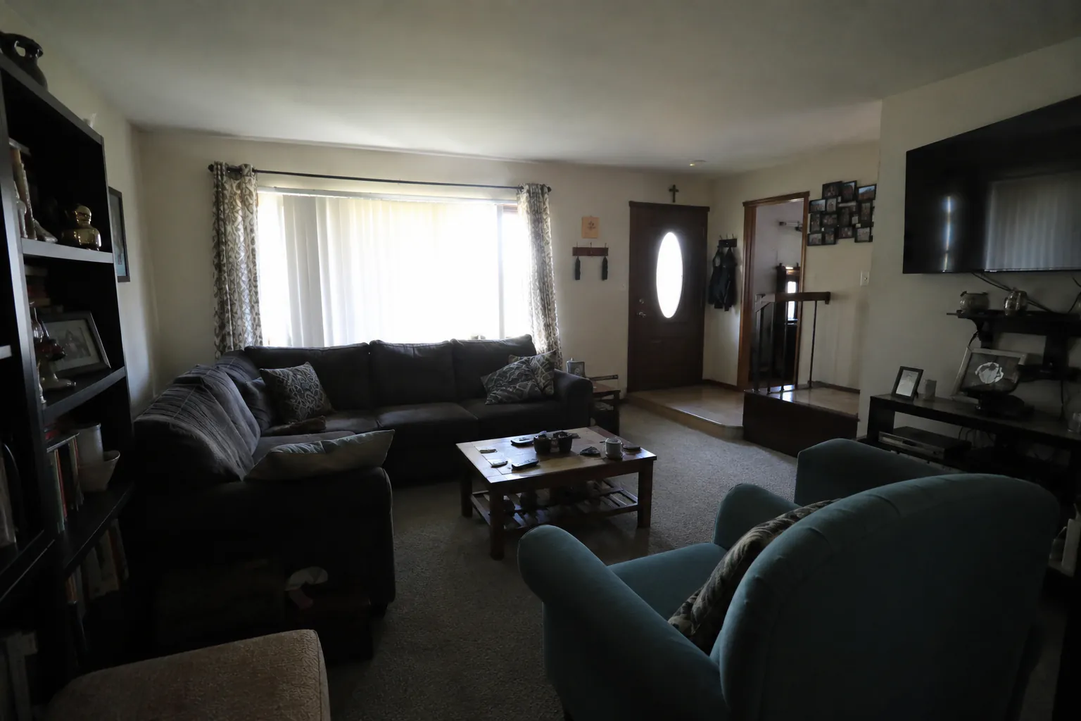 Dim, unedited living room with dark corners and shadowed furniture