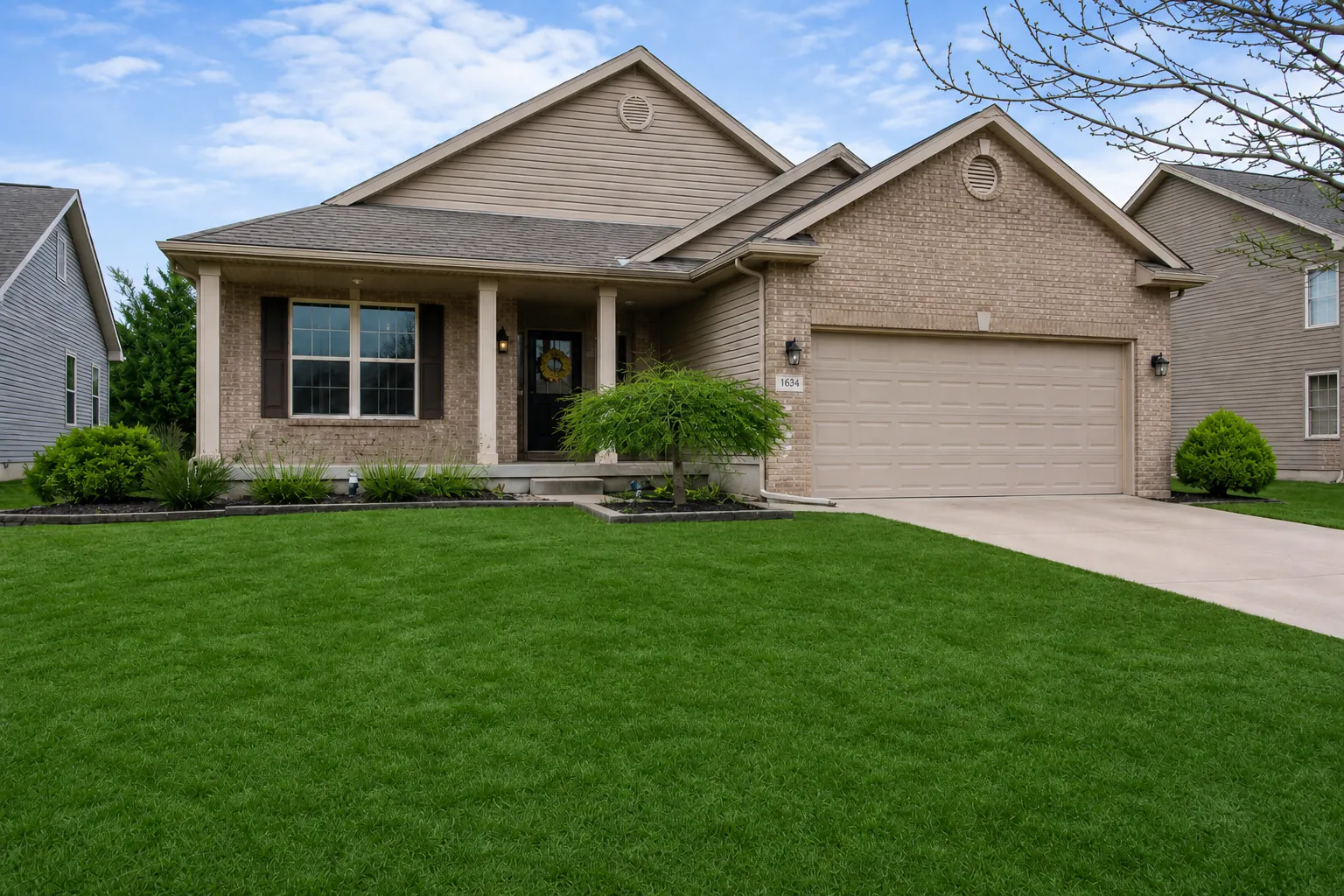 Same front yard after grass greening with a healthy green lawn